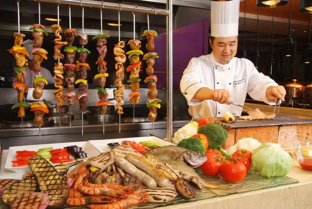 Viandes, poissons et légumes en train de griller sur une plaque chauffante