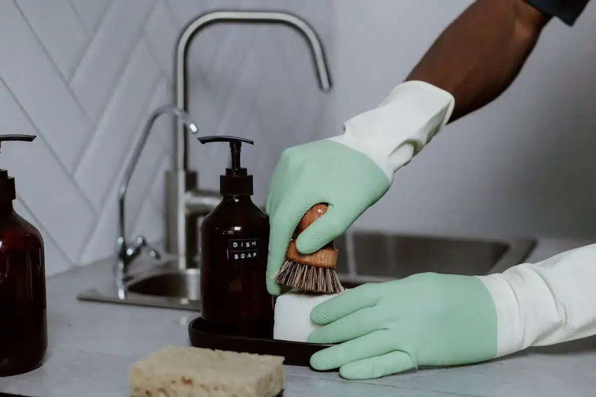 D&eacute;tail du r&eacute;servoir int&eacute;gr&eacute; dans le manche d'une brosse &agrave; vaisselle avec syst&egrave;me de dosage