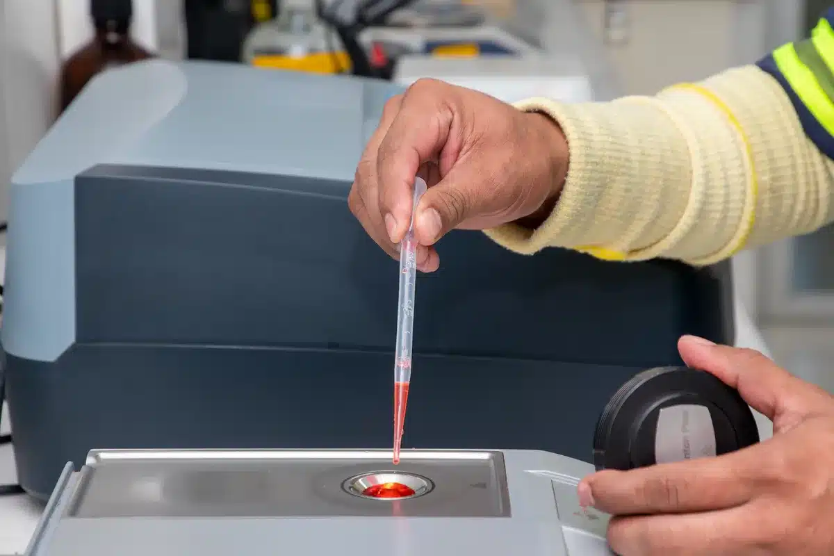 Particules d'argent en suspension dans l'eau avec mousse à la surface, équipement de recyclage en arrière-plan