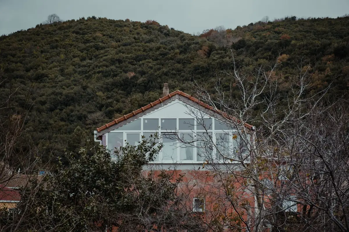 Maison de montagne orient&eacute;e sud avec grandes baies vitr&eacute;es captant la lumi&egrave;re naturelle