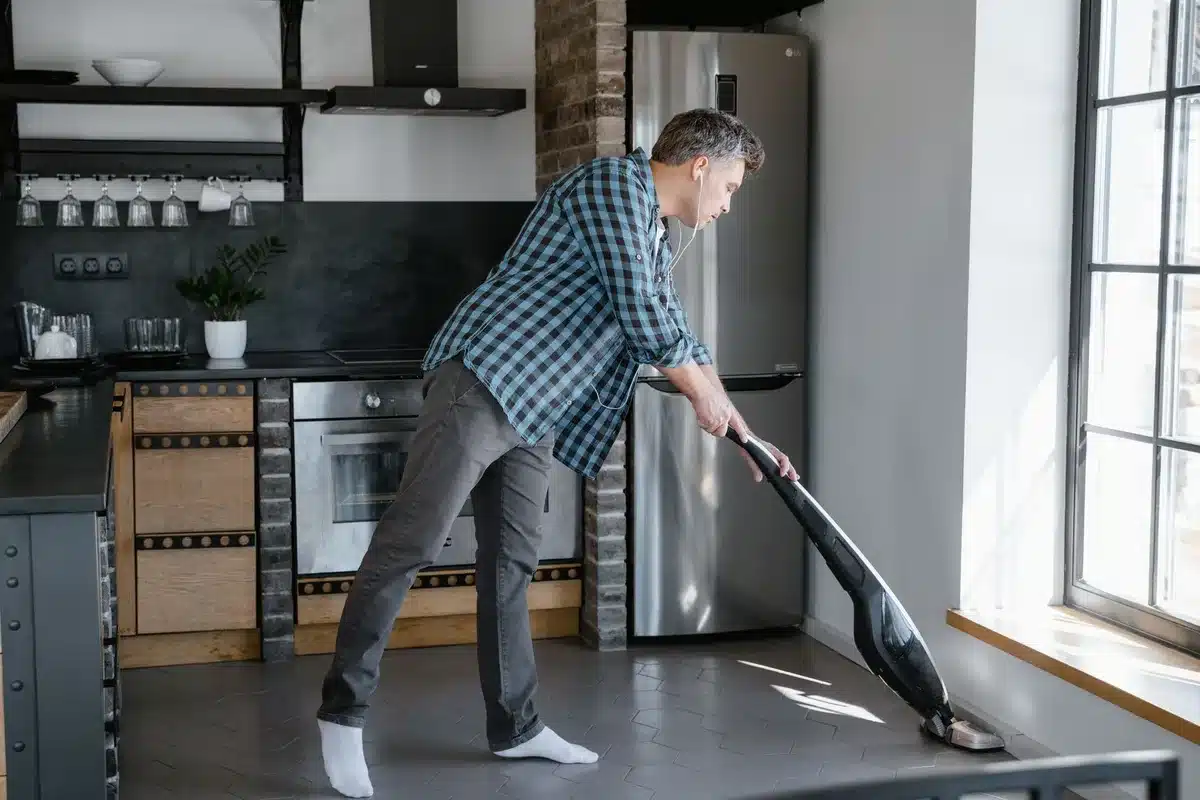 Main compact sans fil aspirant des miettes et un renversement liquide sur plan de cuisine