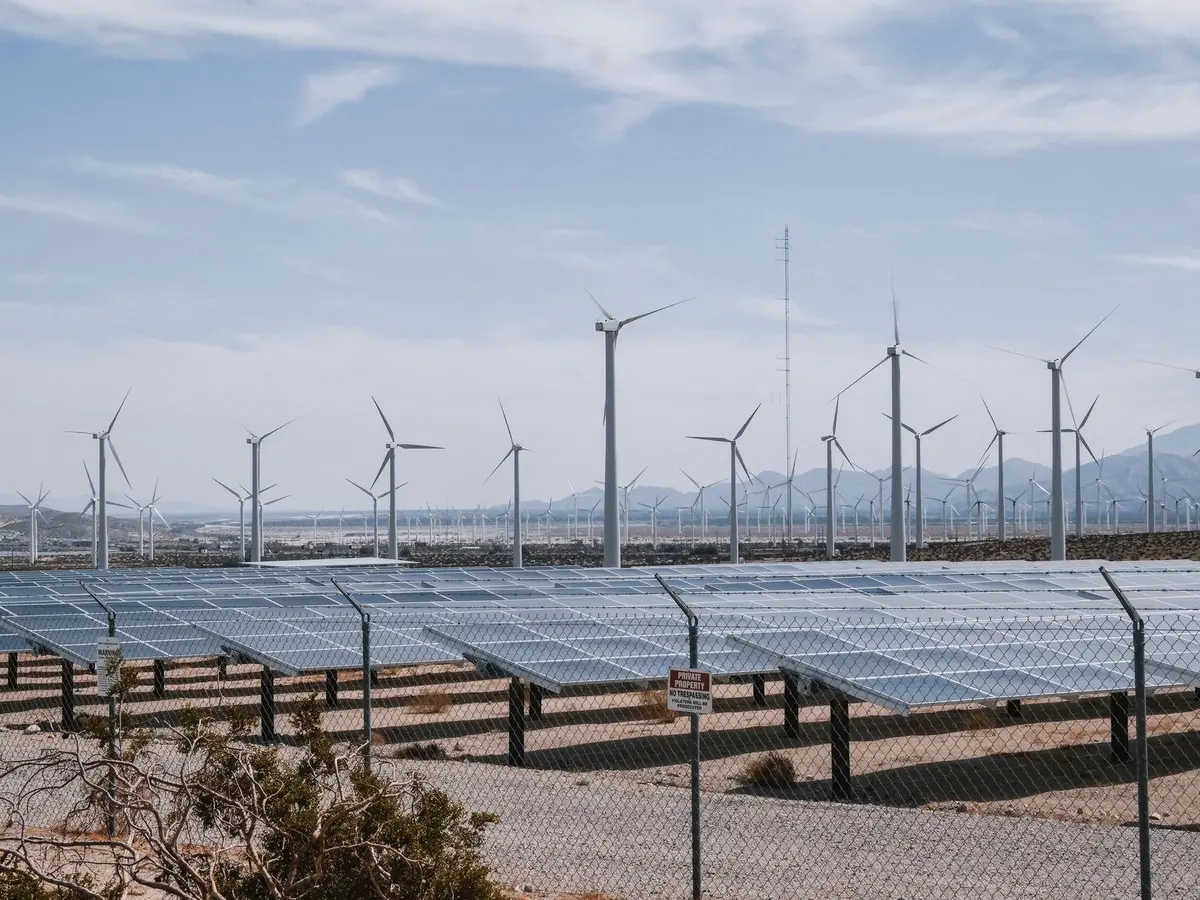 Parc &eacute;olien et panneaux solaires dans un paysage agricole ensoleill&eacute;