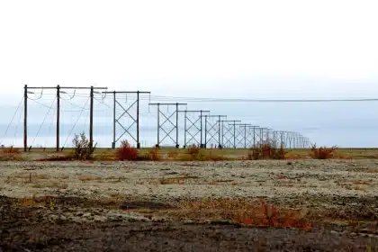 Lignes électriques haute tension traversant un paysage désertique ou montagneux sur des kilomètres