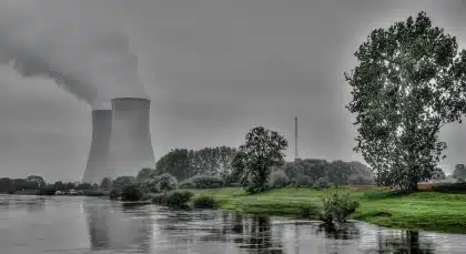 Complexe nucléaire industriel avec tours de refroidissement et structures en acier sous un ciel gris
