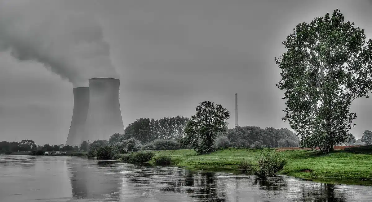 Complexe nucléaire industriel avec tours de refroidissement et structures en acier sous un ciel gris