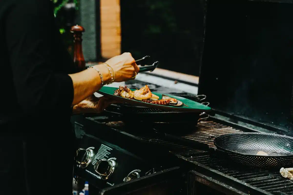 Grill de table compact avec plaques réversibles en cours d'utilisation pour cuire viande et légumes