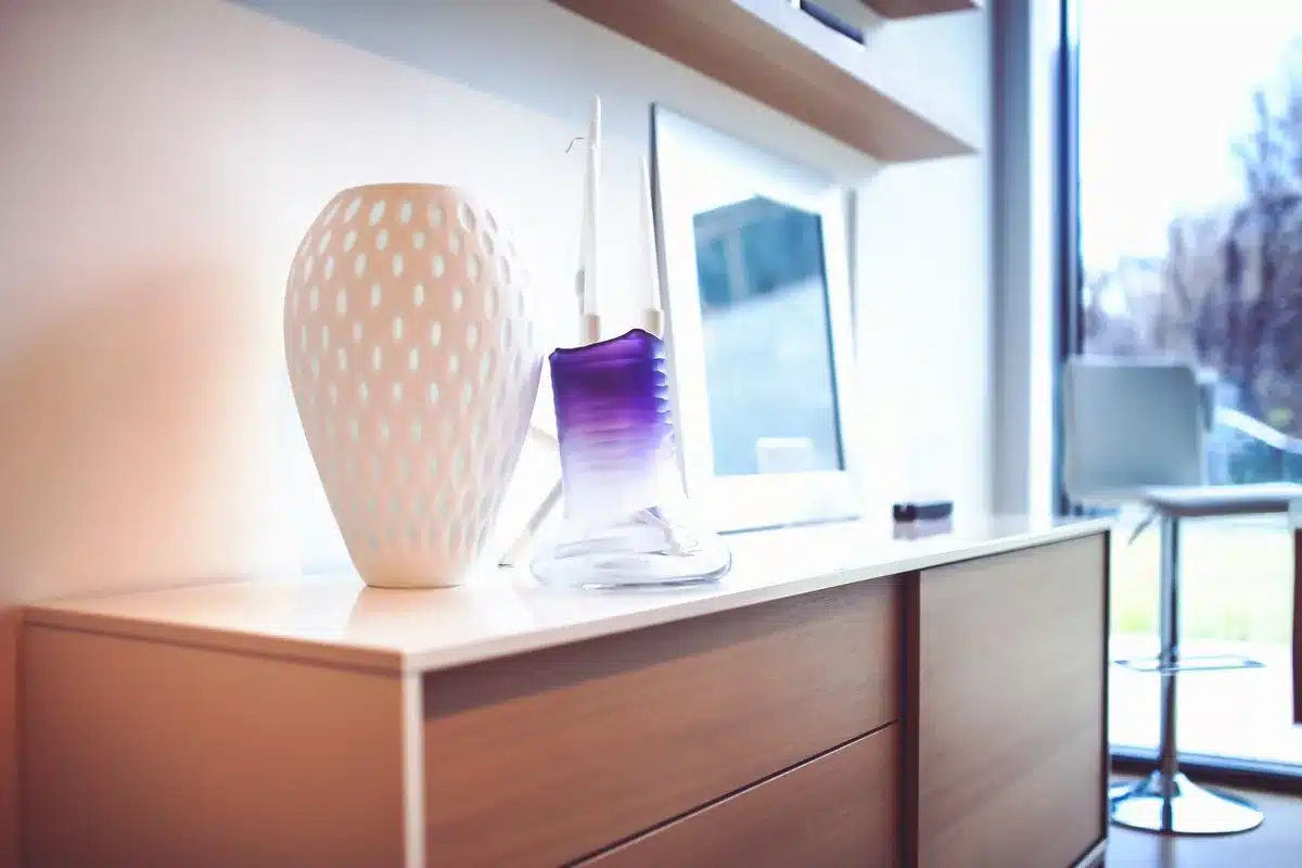 Un coin focal de salon avec &eacute;tag&egrave;re, bougies et vases en terre cuite aux teintes automnales