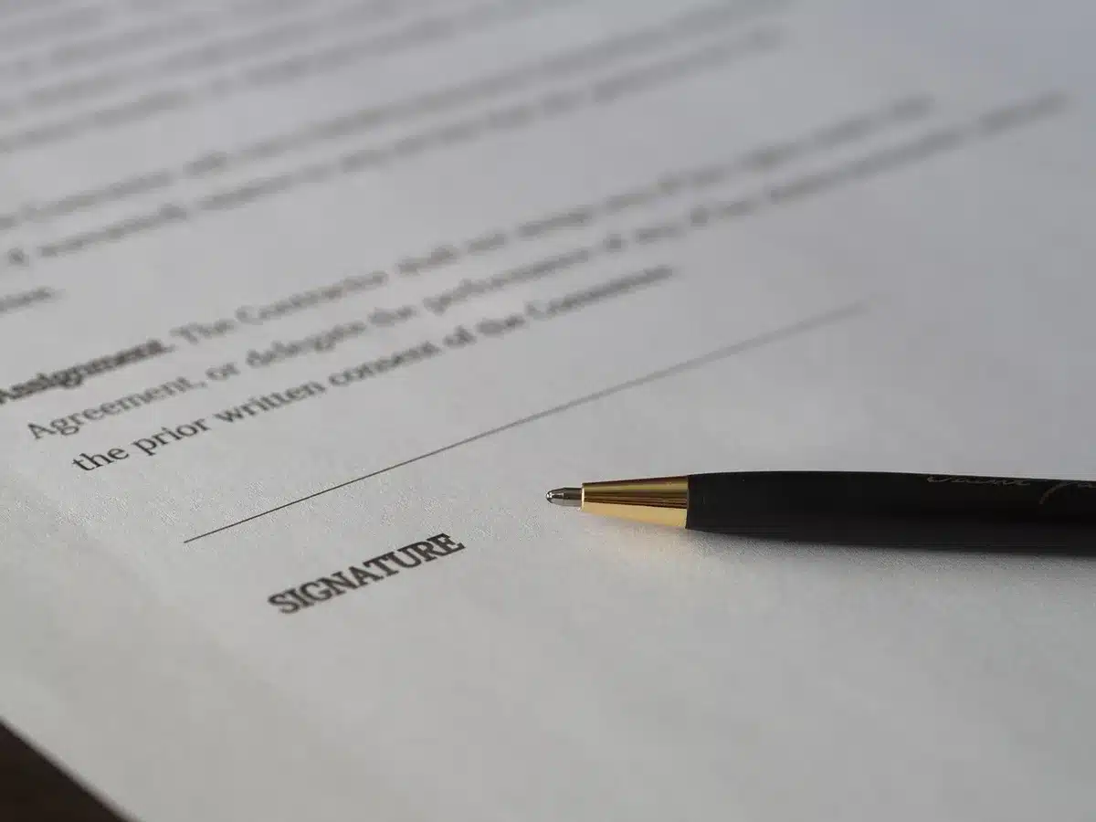 Contrat de location posé sur une table avec des mains anonymes dessus