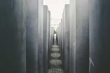 Colonne de rangement étroite dans une petite salle de bains lumineuse avec serviette et pot décoratif