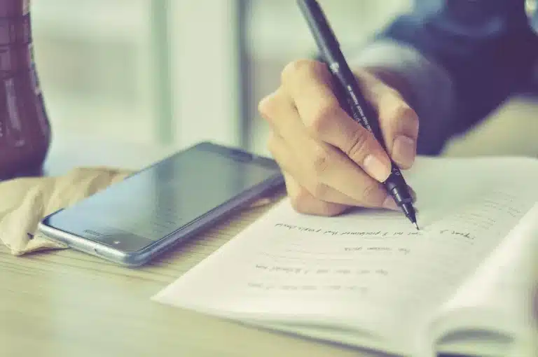 Personne consultant des annonces de location sur un ordinateur portable avec documents et clés d'appartement