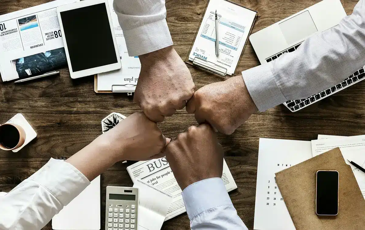 Documents de tutelle et curatelle posés sur une table avec une main tenue en arrière-plan
