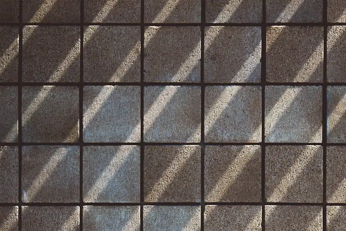 Fissures visibles sur un mur intérieur, de largeurs variées, avec ombres accentuant les dégâts