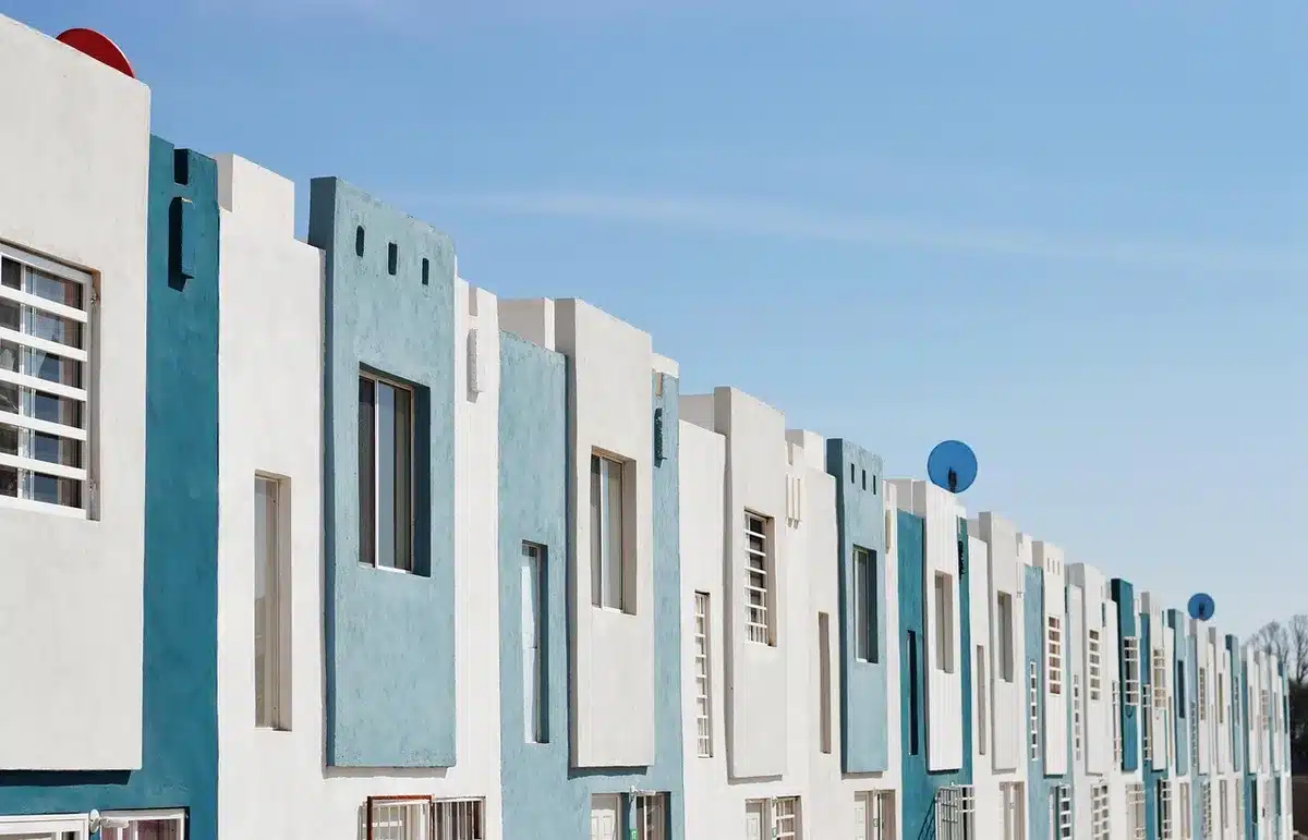 Fa&ccedil;ades de maisons accol&eacute;es montrant un mur mitoyen en plein jour