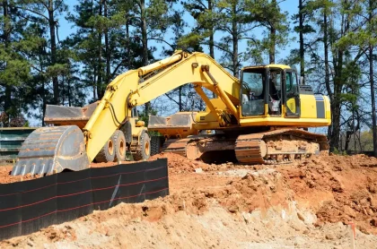Chantier de terrassement avec engins lourds sur site industriel côtier