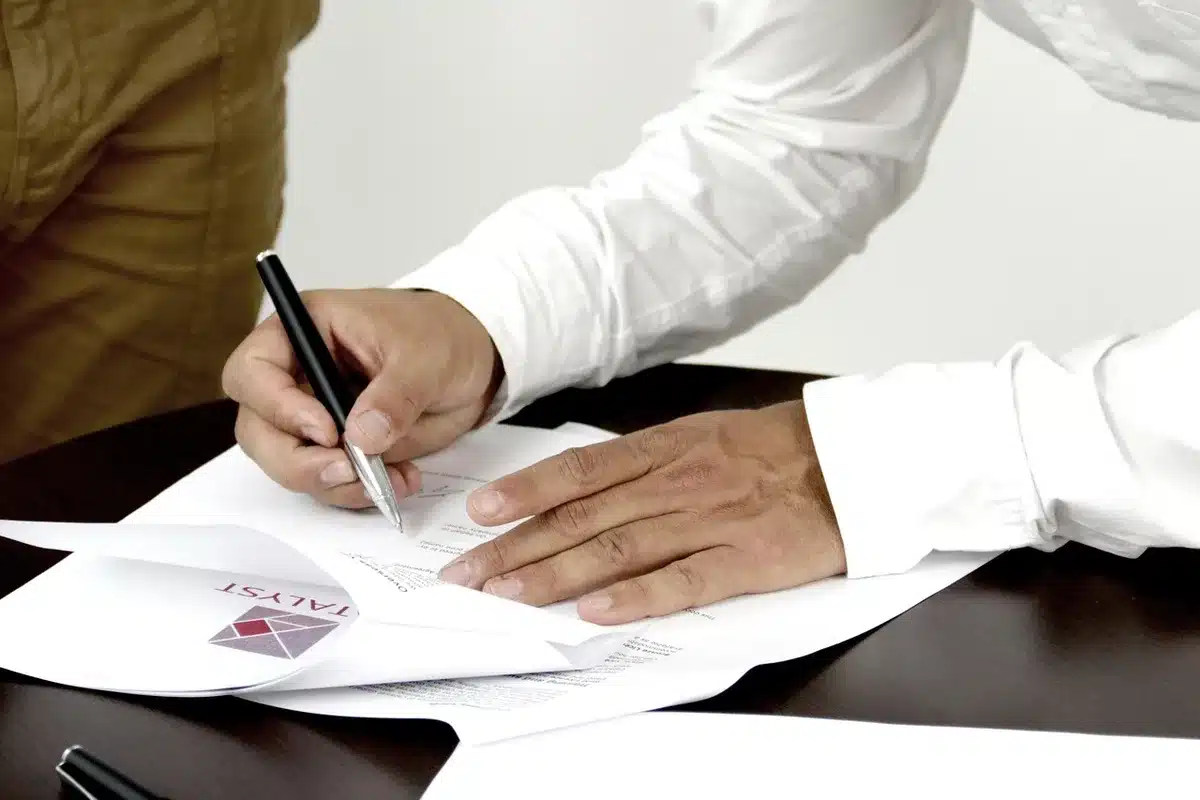 Main signant un compromis de vente avec stylo