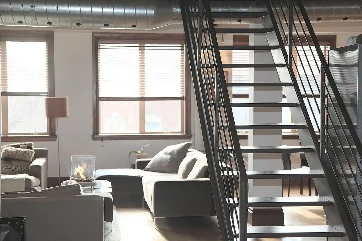 Salon contemporain aux murs greige chauds avec matériaux naturels et éclairage doux