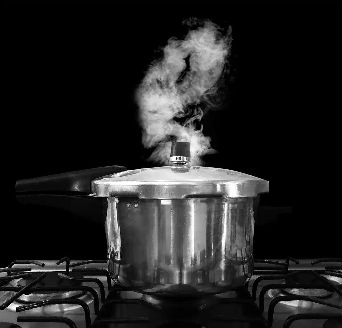 Casserole de confiture sur feu doux avec une cuillère en bois remuant la préparation
