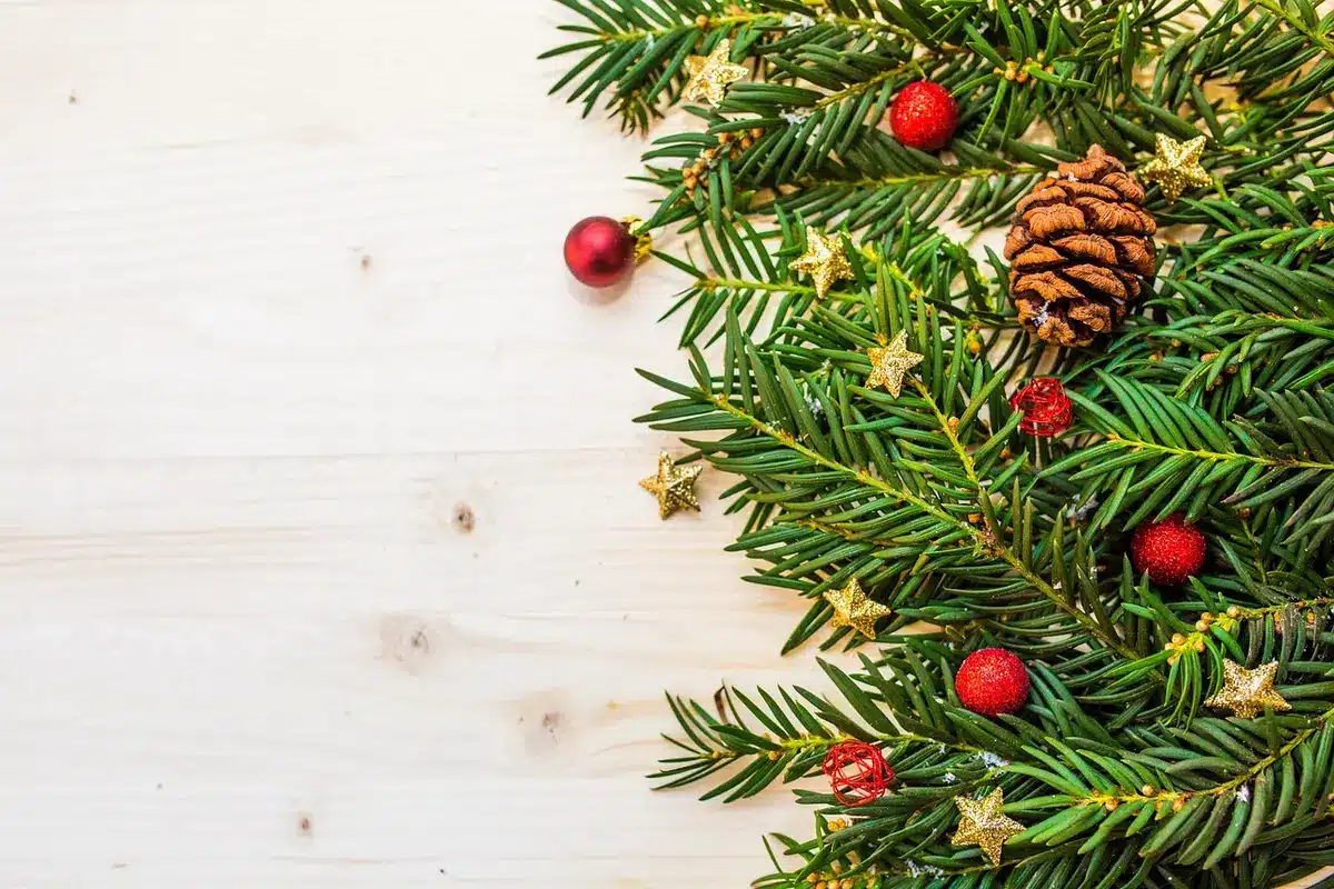 Table de Noël décorée avec touches dorées, rouges et feuillage