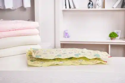 Sac sous vide transparent contenant manteaux et pulls posé dans une chambre lumineuse