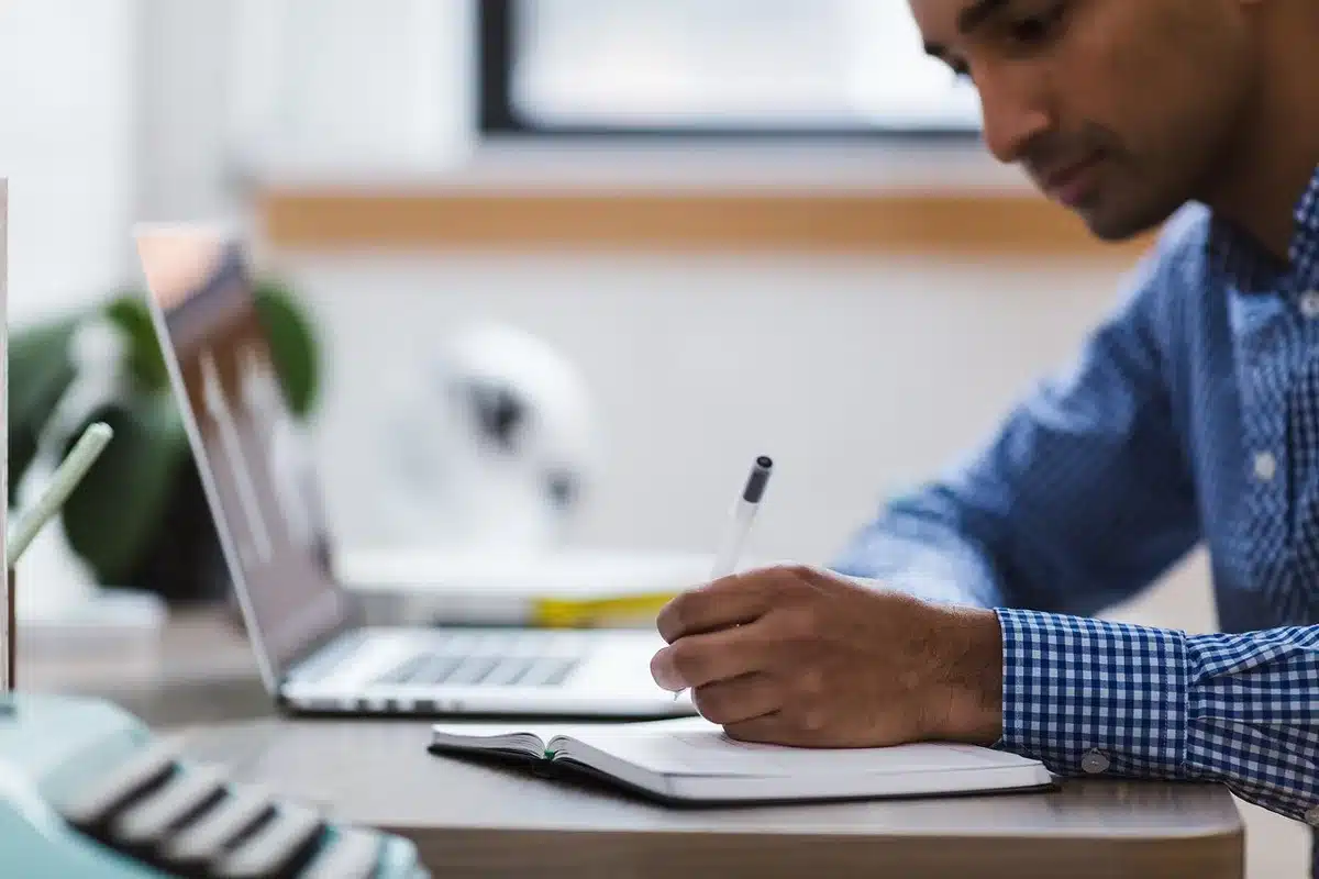 Bureau ensoleillé avec personnes anonymes consultant des graphiques sur un ordinateur portable