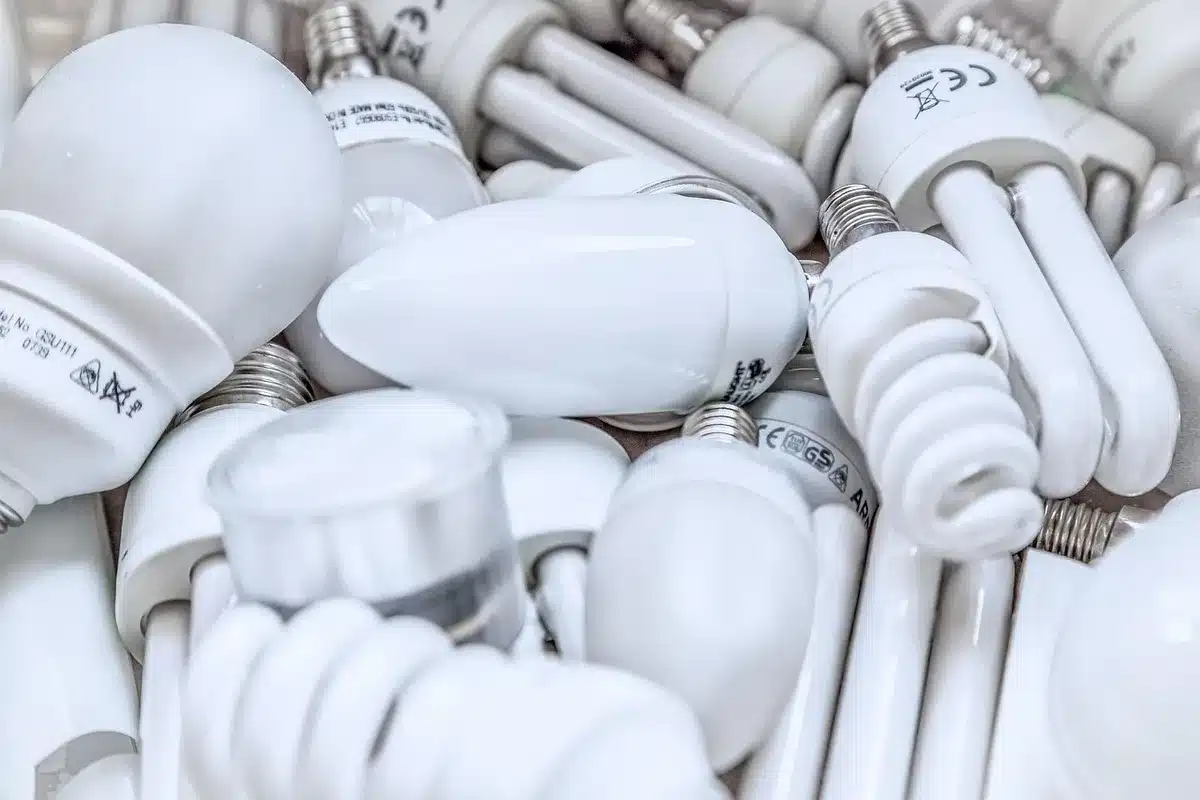 Propriétaire consultant sa facture d'électricité à côté d'un compteur et d'un petit écran de suivi