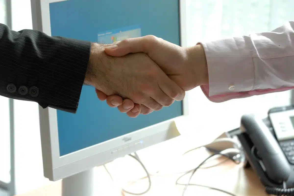 Deux personnes discutant des contrats et d'un plan financier autour d'une table
