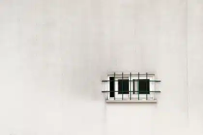 Étendoir vertical compact en acier près d'une fenêtre, vêtements suspendus