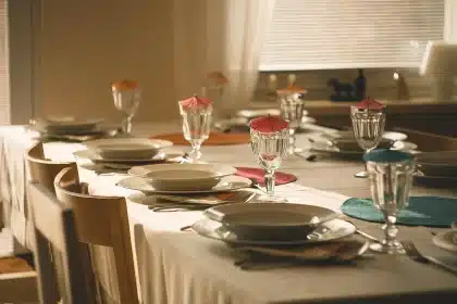 Table dressée en journée avec nappe paisley beige, assiettes neutres et accessoires en bois